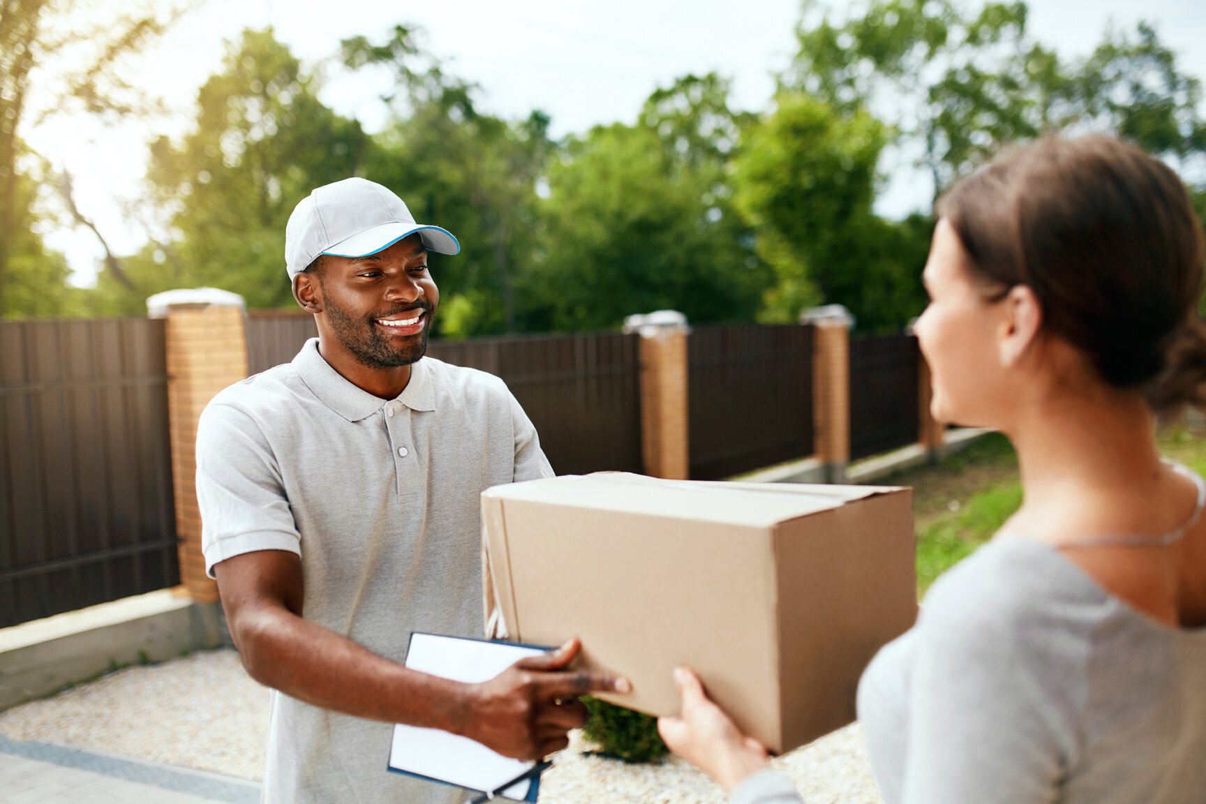 Package Delivering. Delivery Man Delivering Box To Woman