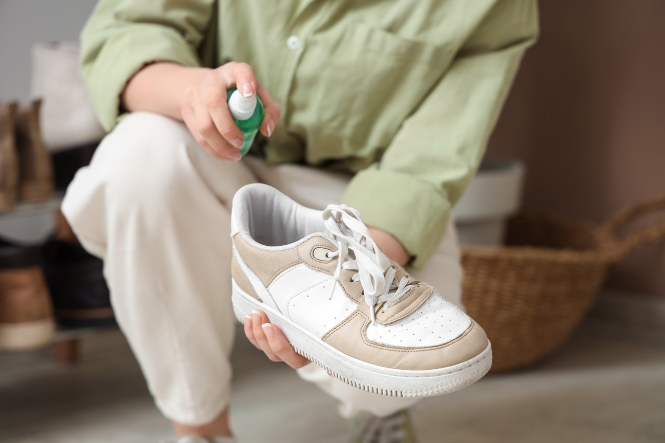 Woman Applying Water Repellent Spray on Stylish Sneaker, Closeup